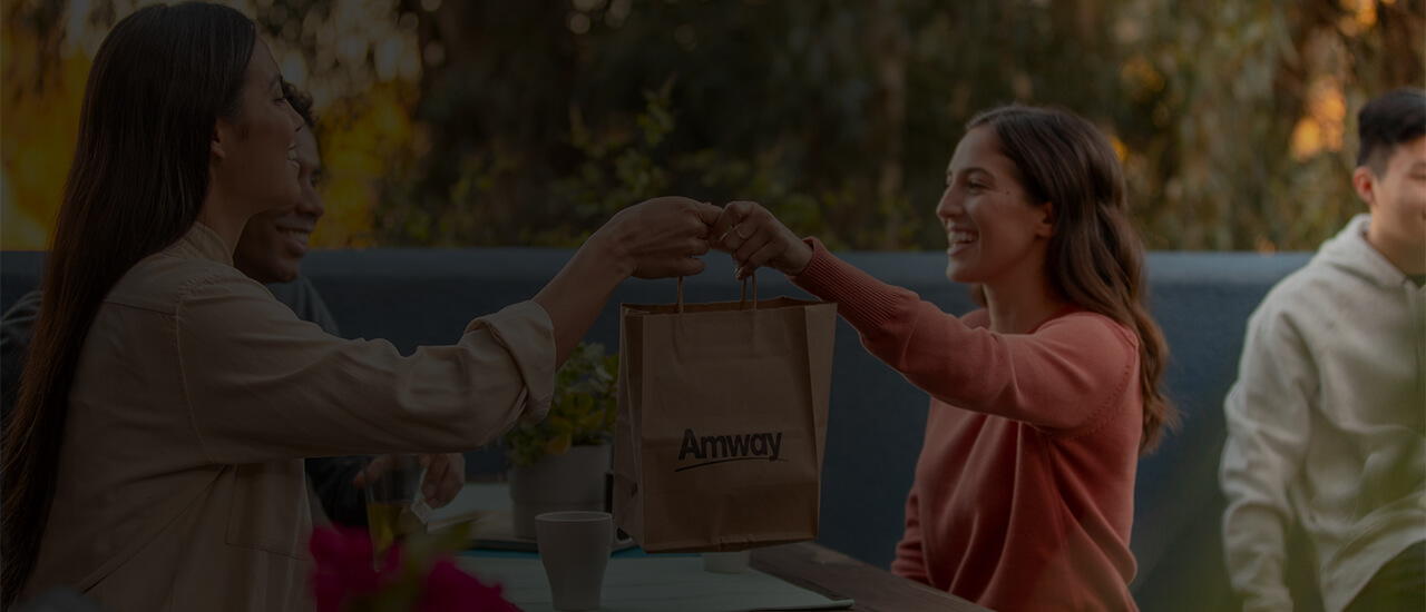 Imagen de un hombre y una mujer reunidos tomando café hablando sobre la Educación Amway desde la página virtual de INA con una tablet.